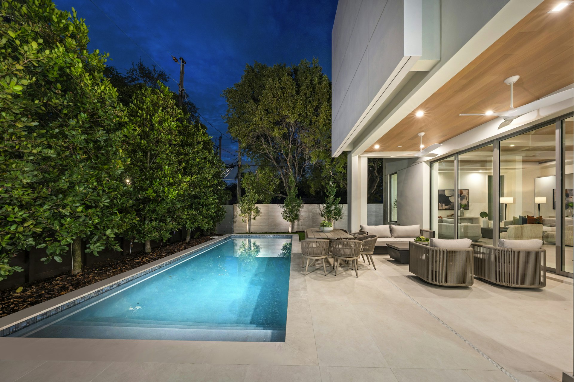 Moderne Villa mit beleuchtetem Pool in der Abenddämmerung